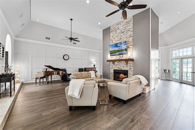 living room with crown molding, ceiling fan, a fireplace, and high vaulted ceiling