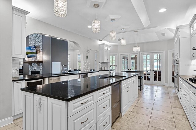 kitchen featuring sink, white cabinetry, a center island, tasteful backsplash, and french doors