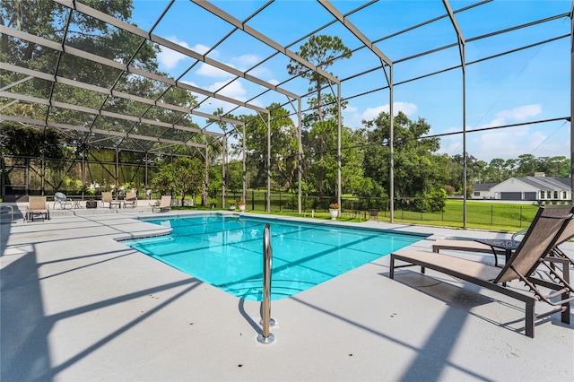 view of swimming pool with a patio, a yard, and glass enclosure