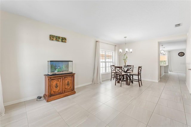 dining area with a notable chandelier and light tile patterned flooring