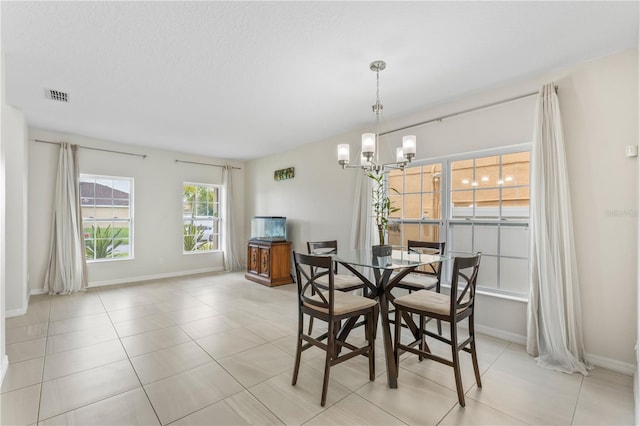 dining space featuring light tile patterned floors and an inviting chandelier