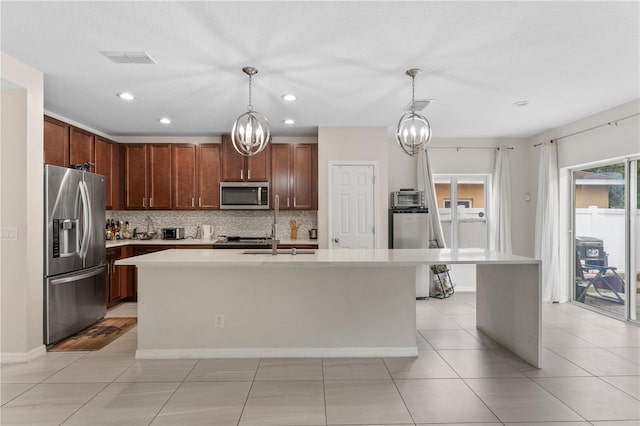 kitchen featuring a kitchen island with sink, tasteful backsplash, appliances with stainless steel finishes, and light tile patterned floors