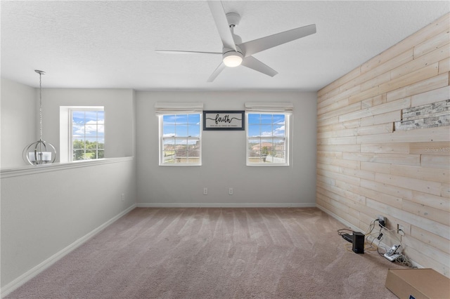 empty room featuring ceiling fan, a textured ceiling, and carpet flooring