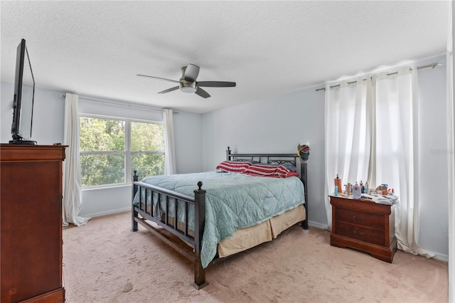 carpeted bedroom with ceiling fan and a textured ceiling