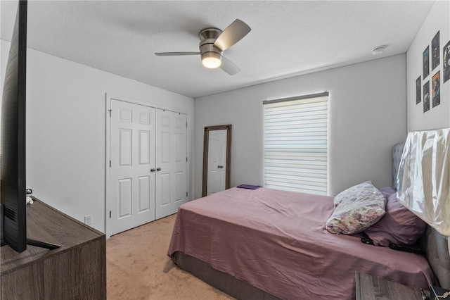 carpeted bedroom featuring ceiling fan and a closet