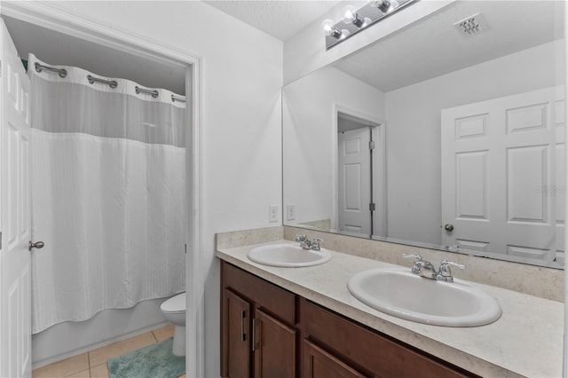 full bathroom with shower / tub combo with curtain, vanity, tile patterned floors, a textured ceiling, and toilet