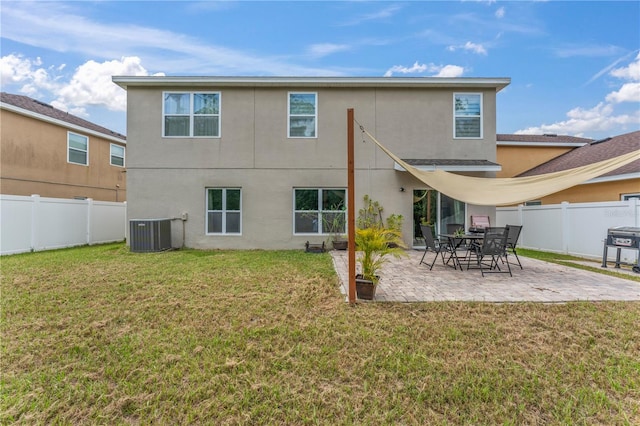 back of house featuring a lawn, central AC unit, and a patio