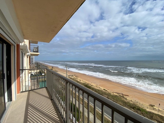 balcony with a beach view and a water view