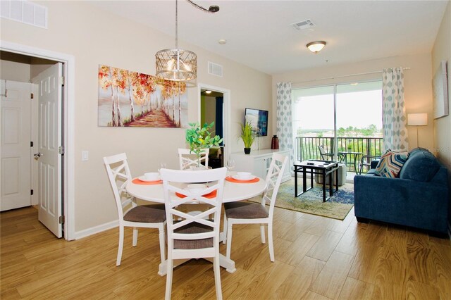 dining area with an inviting chandelier and light wood-type flooring