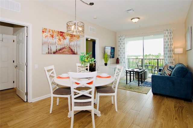 4114 Breakview Dr Unit 406, Orlando, FL 32819 - dining area with a chandelier, light wood-style flooring, and visible vents