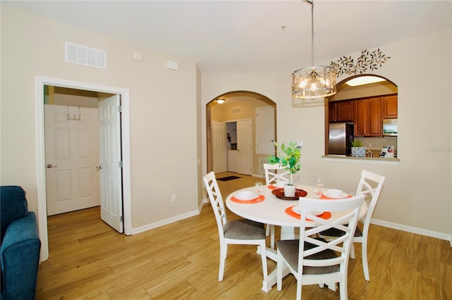 4114 Breakview Dr Unit 406, Orlando, FL 32819 - dining space with arched walkways, light wood-type flooring, visible vents, and baseboards