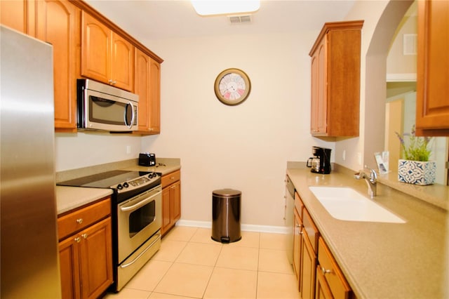 kitchen featuring sink, light tile patterned flooring, and stainless steel appliances