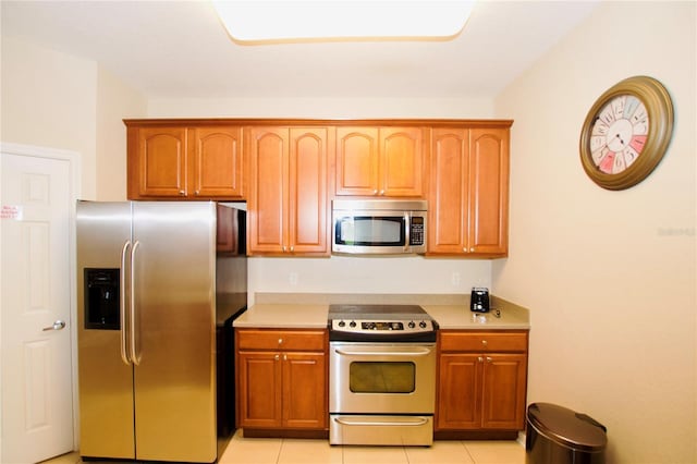 4114 Breakview Dr Unit 406, Orlando, FL 32819 - kitchen with stainless steel appliances, brown cabinets, light countertops, and light tile patterned flooring