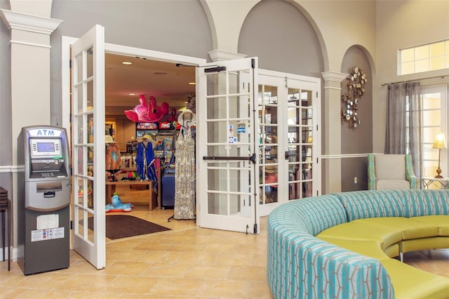 4114 Breakview Dr Unit 406, Orlando, FL 32819 - living area featuring arched walkways, french doors, a towering ceiling, and decorative columns