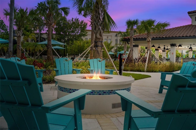 patio terrace at dusk featuring an outdoor fire pit