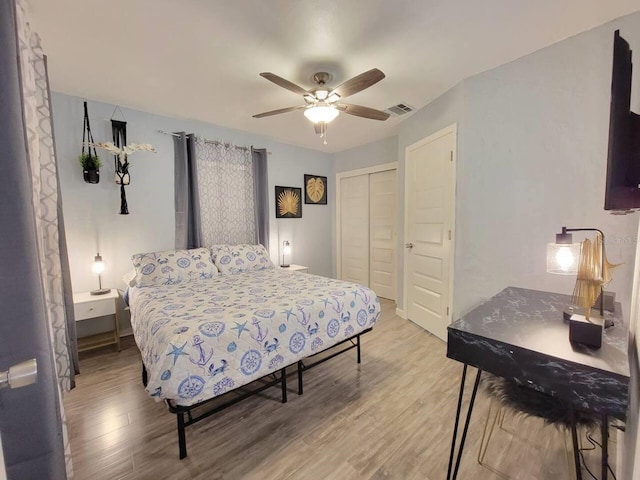 bedroom with hardwood / wood-style flooring, ceiling fan, and a closet