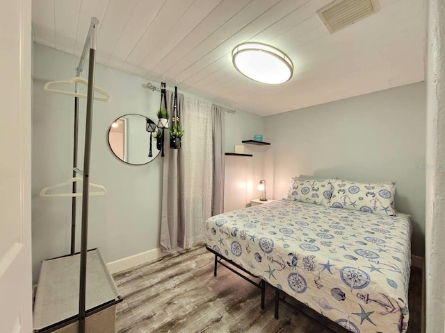 bedroom with wood ceiling and wood-type flooring