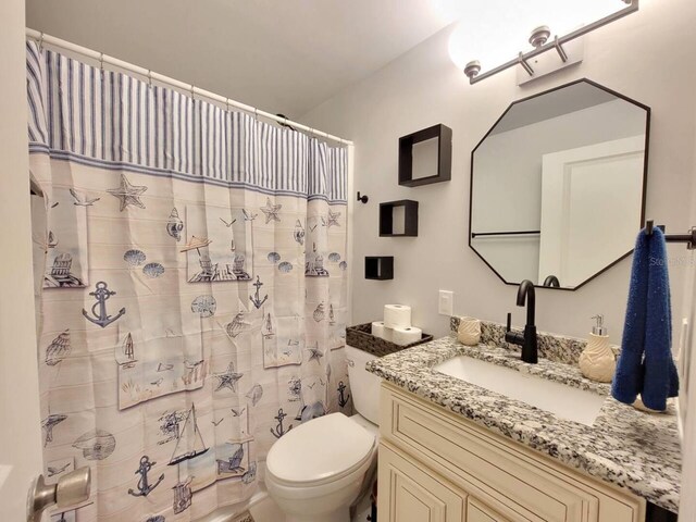 bathroom featuring a shower with curtain, vanity, and toilet