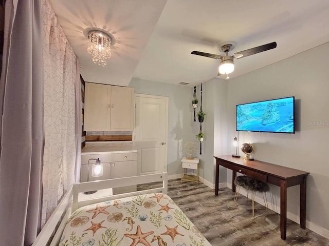 bedroom featuring hardwood / wood-style flooring and ceiling fan with notable chandelier