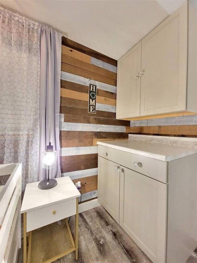 kitchen with dark hardwood / wood-style flooring and wood walls