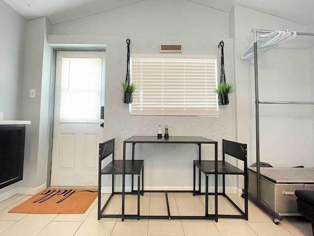 tiled dining area featuring lofted ceiling