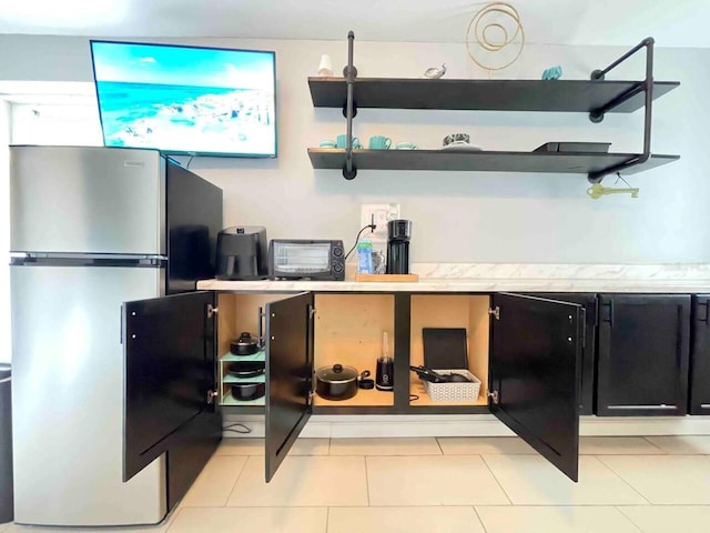 kitchen featuring stainless steel refrigerator and light tile patterned flooring