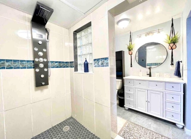 bathroom featuring vanity, toilet, and tiled shower