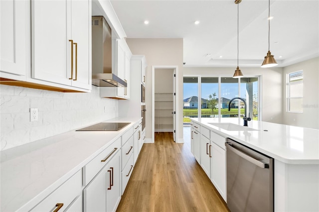 815 Liliana Dr, Deland, FL 32724 - kitchen featuring stainless steel dishwasher, wall chimney range hood, a sink, black electric stovetop, and light wood-style flooring