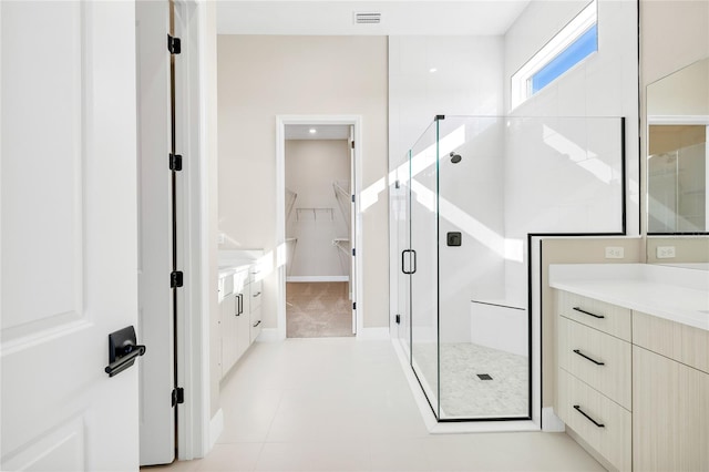 bathroom with vanity, a shower with shower door, and tile patterned floors