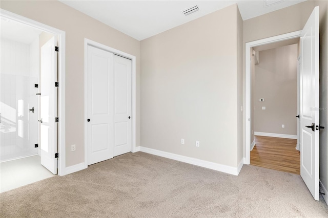 unfurnished bedroom featuring a closet and light carpet