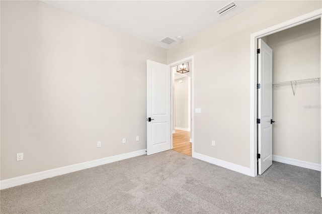 unfurnished bedroom featuring light colored carpet and a closet