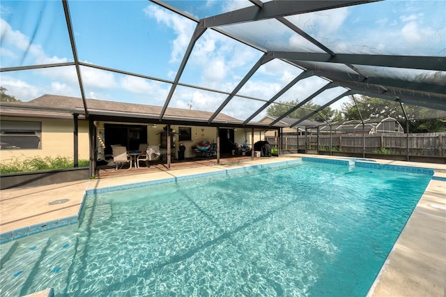 view of pool with glass enclosure and a patio area