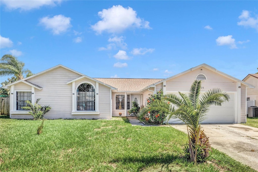 ranch-style house with driveway, central air condition unit, an attached garage, and a front yard