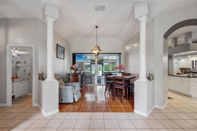 living room with ornate columns, light tile patterned floors, and an inviting chandelier