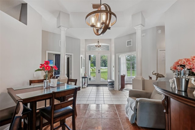 dining room featuring decorative columns, french doors, tile patterned floors, and a chandelier