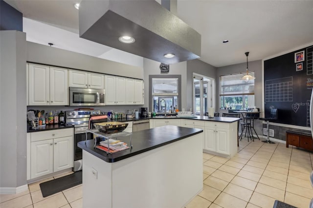 kitchen featuring appliances with stainless steel finishes, white cabinetry, light tile patterned floors, kitchen peninsula, and hanging light fixtures