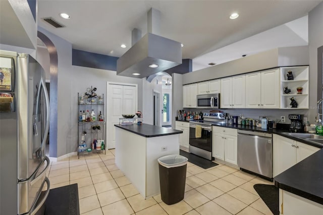 kitchen featuring white cabinetry, appliances with stainless steel finishes, light tile patterned flooring, and a kitchen island