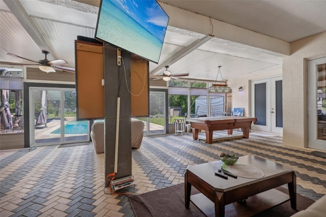 interior space with ceiling fan, a wealth of natural light, french doors, and beamed ceiling