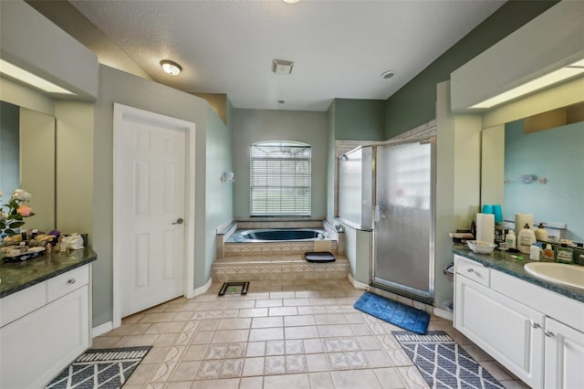 bathroom featuring tile patterned flooring, vanity, and shower with separate bathtub