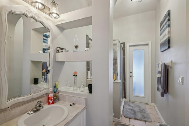 bathroom with tile patterned flooring, vanity, and walk in shower