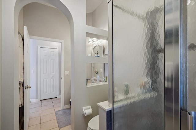 bathroom with tile patterned flooring, an enclosed shower, and toilet