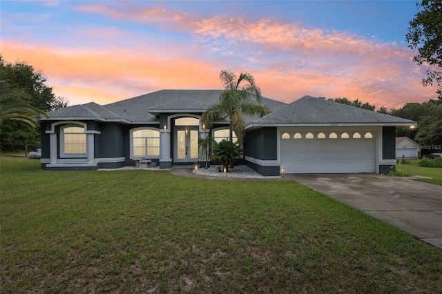 prairie-style home featuring a garage and a lawn