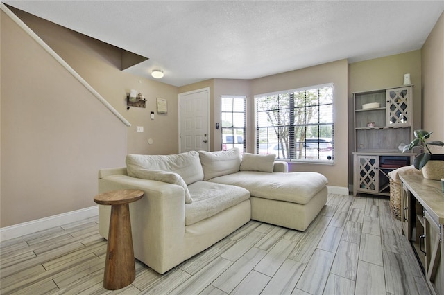 living room with a textured ceiling, baseboards, and wood tiled floor