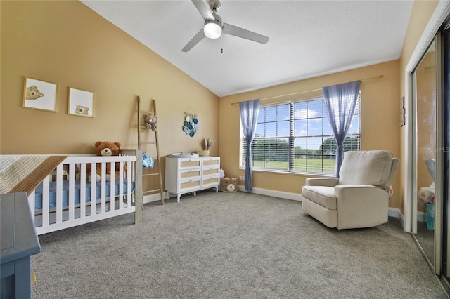 bedroom with a nursery area, vaulted ceiling, ceiling fan, carpet floors, and a closet