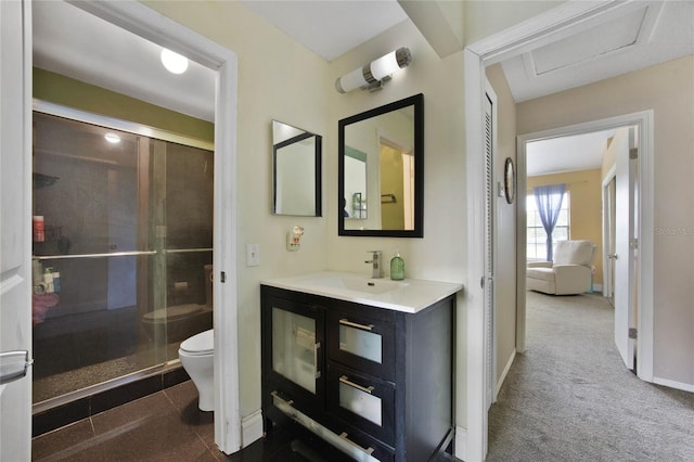 bathroom featuring vanity, a shower stall, toilet, and baseboards