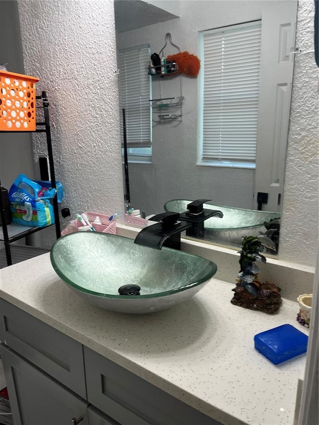 bathroom featuring a textured wall and vanity