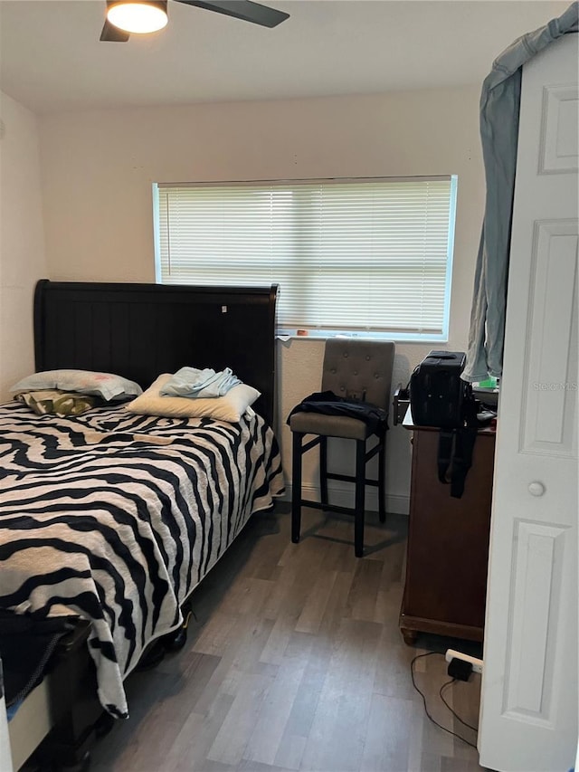 bedroom with ceiling fan, multiple windows, and wood finished floors