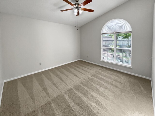 empty room featuring carpet, ceiling fan, and vaulted ceiling