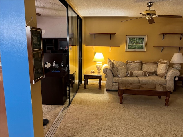 living room featuring a textured ceiling, carpet floors, and ceiling fan