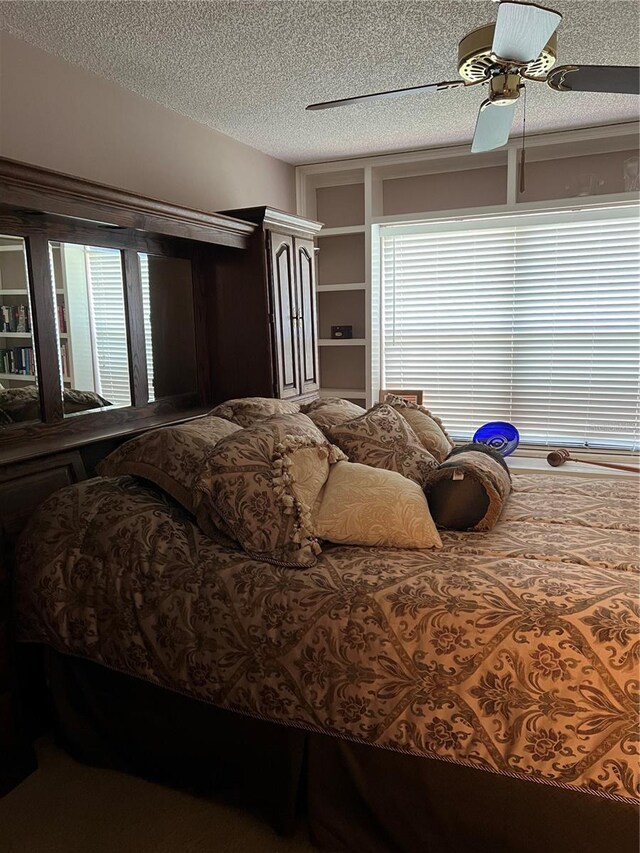 bedroom featuring ceiling fan and a textured ceiling